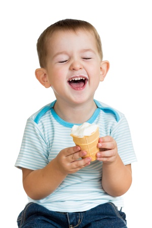 happy kid boy eating ice cream in studio isolatedの写真素材