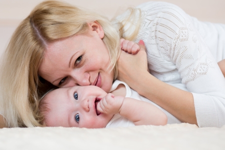 mother playing with  baby boy indoorsの写真素材