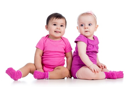 Funny babies girls sitting beside on floorの写真素材