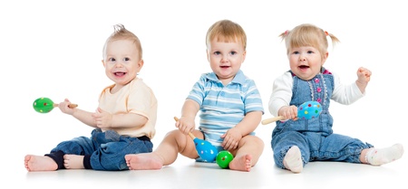 Babies playing with musical toys  Two boys and girl with maracas isolated on white backgroundの写真素材