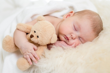 newborn baby sleeping on fur bedの写真素材
