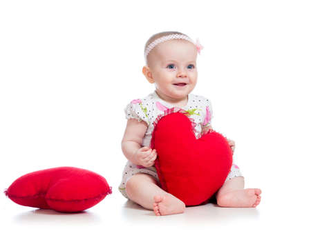 baby girl with pillow in heart shapeの写真素材