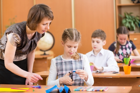 School kids work at labour lesson  Teacher looking at pupil の写真素材
