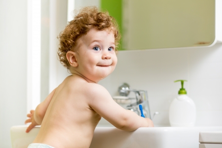 baby brushing teeth in bathroomの写真素材