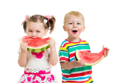 kids boy and girl eat watermelon isolated on whiteの写真素材
