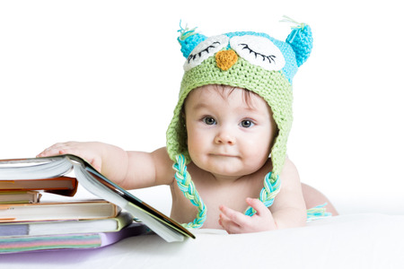 baby in funny owl knitted  hat owl with books  on white backgroundの写真素材