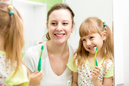 mother teaches kid brushing teethの写真素材