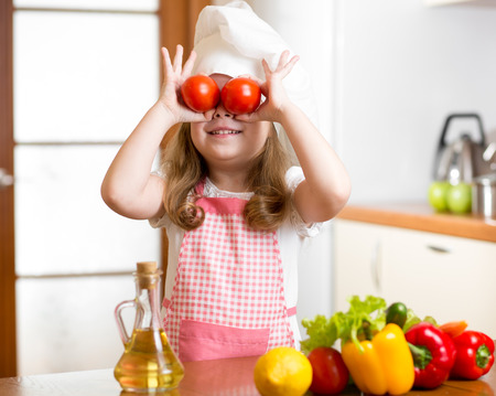 Funny chef girl preparing healthy food at kitchenの写真素材