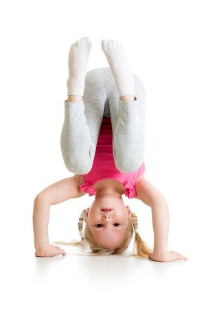 kid girl standing head over heels and smiling, isolated on white backgroundの写真素材