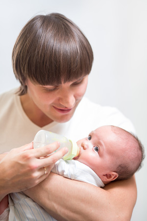 father feeding his baby infant from bottleの写真素材