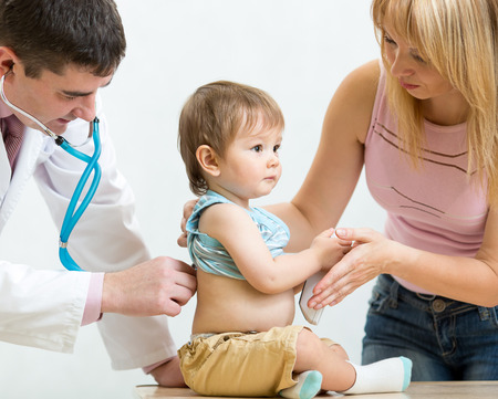 Pediatrician male doctor examining child. Mother supporting kid.の写真素材