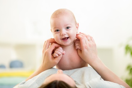 Mother with baby have a fun at homeの写真素材