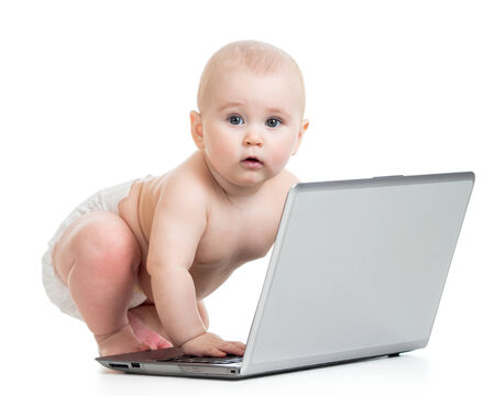 funny baby playing on laptop isolated on white backgroundの写真素材