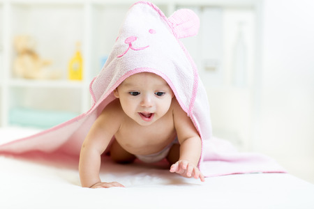 baby under the towel after bathing at homeの写真素材