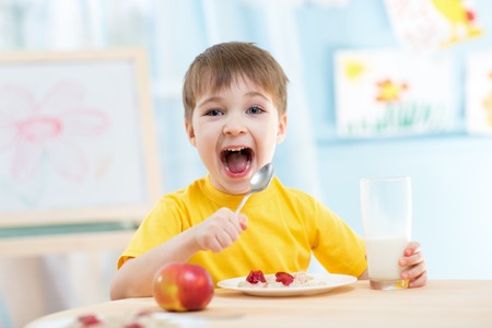 kid boy eating healthy food at homeの写真素材