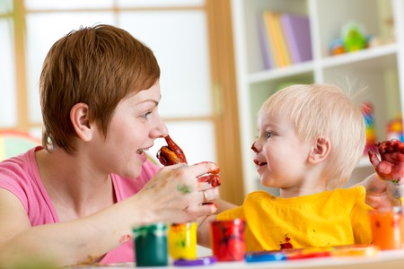 mother and child have fun with paints at homeの写真素材