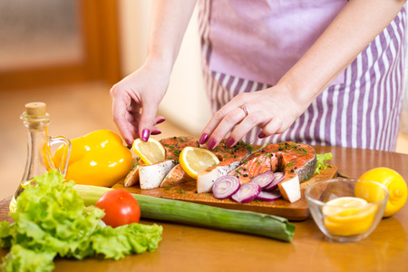 Close up cooking salmon fish in domestic kitchenの写真素材