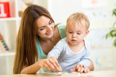 mother and her child playing with colorful puzzle toyの写真素材