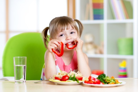 child eating healthy food in kindergarten or at home