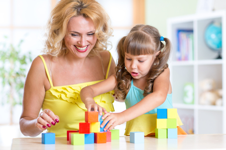 Family - mother and daughter kid playing color wooden bricks.の写真素材