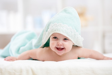 Adorable happy baby under towel indoorの写真素材