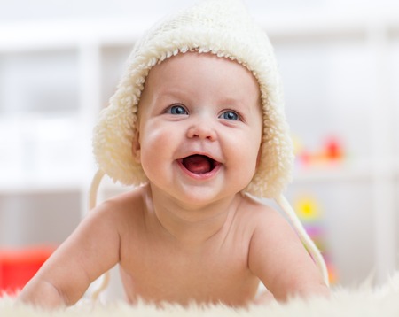 Cute little baby boy looking into the camera and weared in white hat.の写真素材