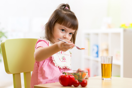 Cute child little boy eating healthy food in kindergartenの写真素材
