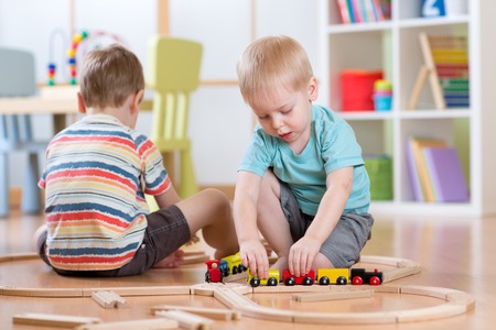 Children playing rail road toy in nurseryの写真素材