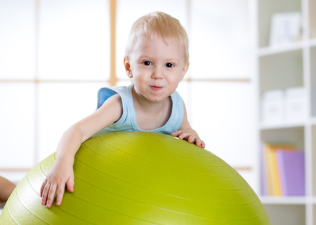 cute child playing with fitness ball indoorsの写真素材