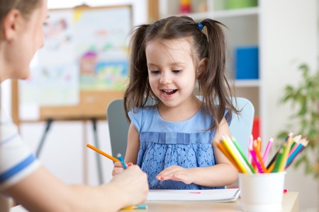 Woman helping her child daughter with homeworkの写真素材