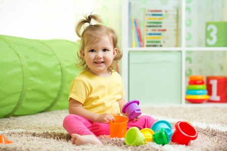 Cheerful kid toddler playing in nursery roomの写真素材