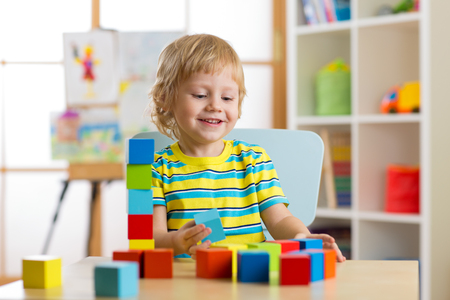 kid boy playing with block toys in day care centerの写真素材
