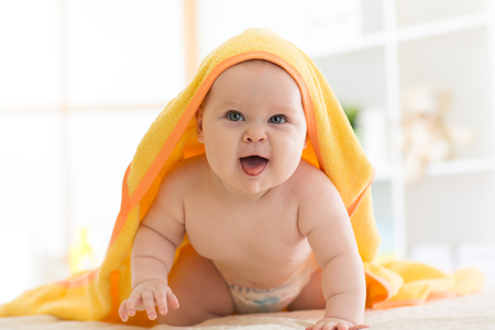 baby under the towel after bathing at homeの写真素材