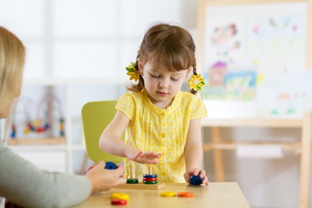 Kid is playing with educational toys in nurseryの写真素材