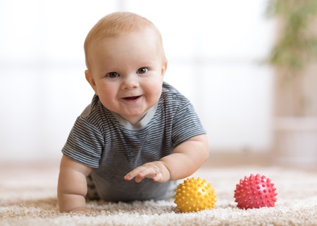 adorable baby crawling on fluffy carpet at homeの写真素材