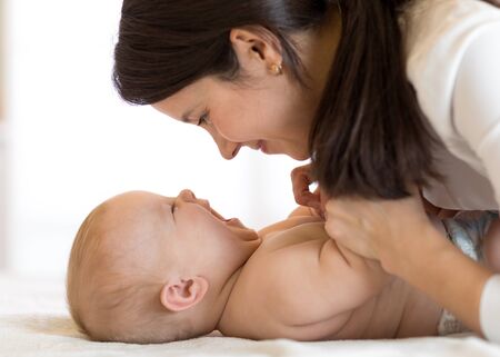 happy mother playing with newborn baby