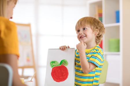 Little child boy holding his drawing for mumの写真素材