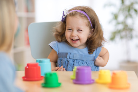 2 year-old child playing with educational cup toys at home.の写真素材