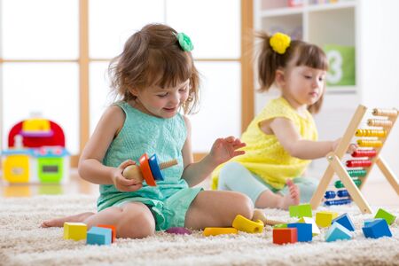 Kids are engaging in daycare. Two toddler children playing with educational toys in kindergarten.の写真素材