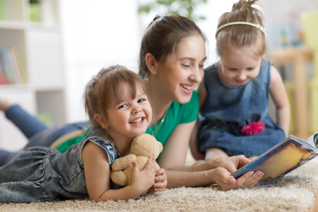Young woman with children read storybookの写真素材
