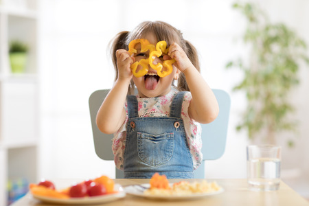kid girl having fun with food vegetables at nursery roomの写真素材