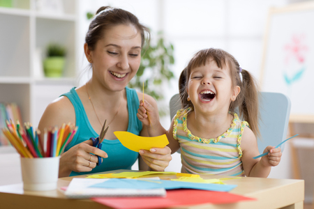 mother with little daughter fun cut scissors colored paperの写真素材