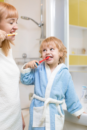 Mother and child brushing teeth together in the morning - Dental care conceptの写真素材
