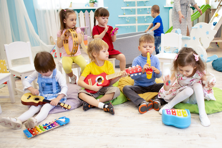Kids learning musical instruments on lesson in kindergarten or preschoolの写真素材