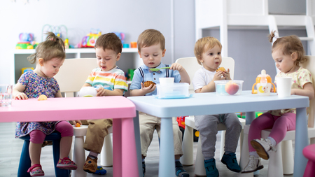 Nursery babies eating food. Kids have lunch in daycareの写真素材