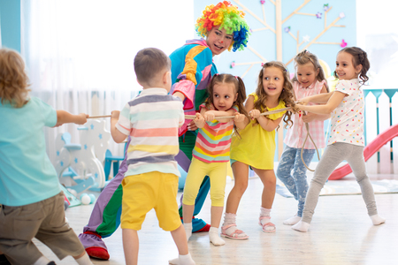 Excited kids playing tug-of-war in clubの写真素材