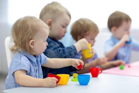 kids group learning arts and crafts in playroom with interestの写真素材