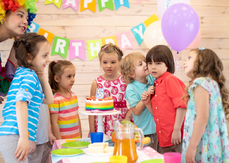 Cute little kid congratulating friend birthday boyの写真素材