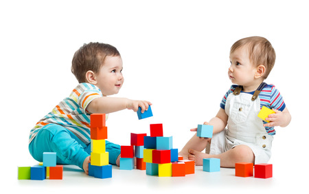 Two kids building block towers. Isolated on white backgroundの写真素材
