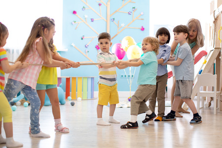 Group of children in a rope-pulling contest in kindergartenの写真素材